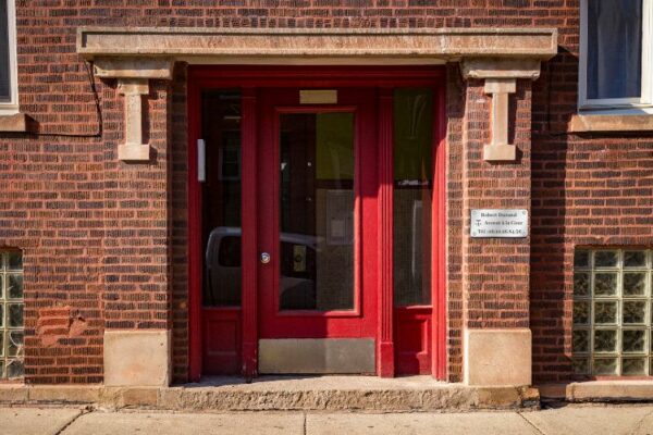 plaques professionnelles devant une porte d'immeuble